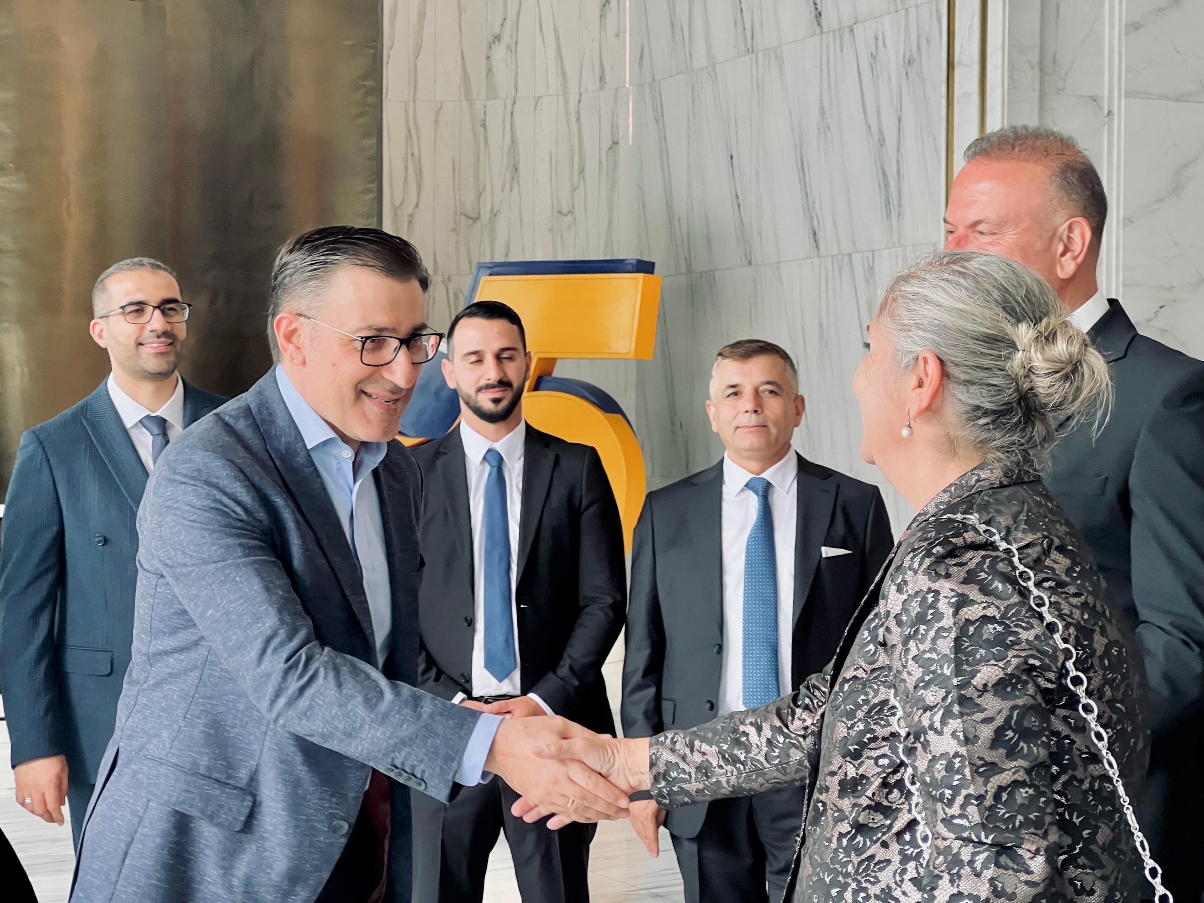 Kurumsal paydaşların resmi etkinlik alanında tokalaşarak görüştüğü an